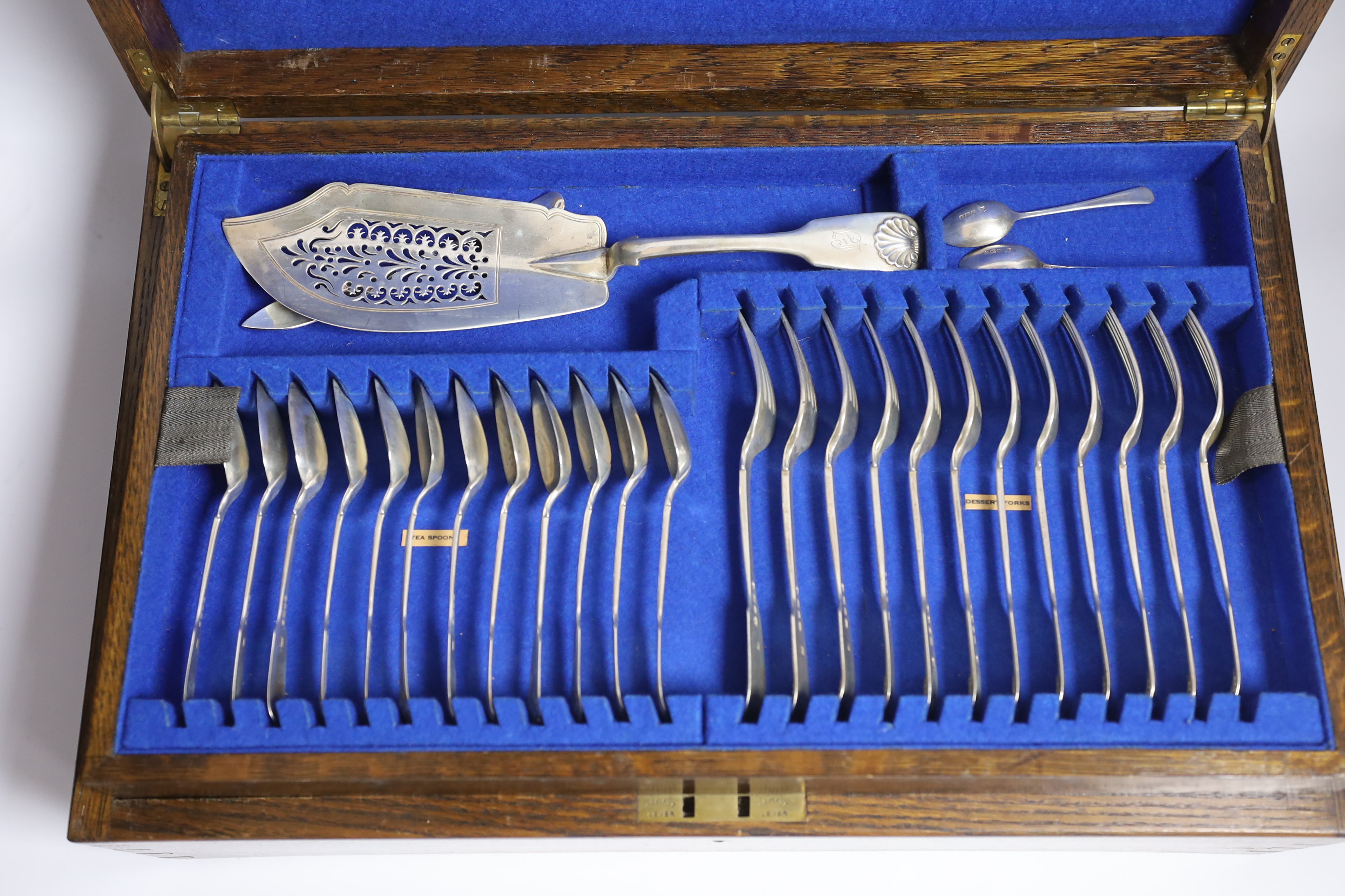 A Victorian oak cased matched canteen of silver fiddle and shell pattern flatware, by John & Henry Lias & H.J. Lias & Son